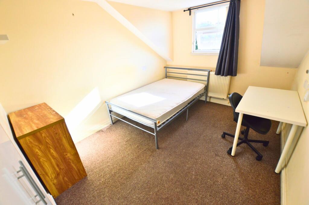 A bright and tidy single bedroom featuring a co...