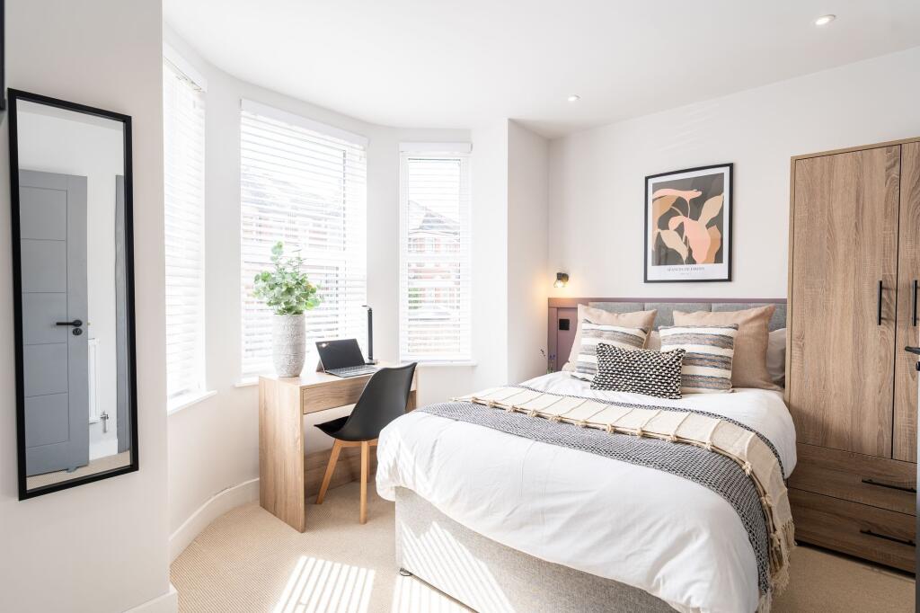 A bright and welcoming double bedroom featuring...