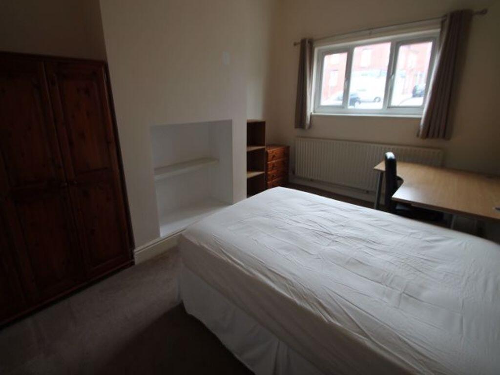 A cozy single bedroom featuring a comfortable b...