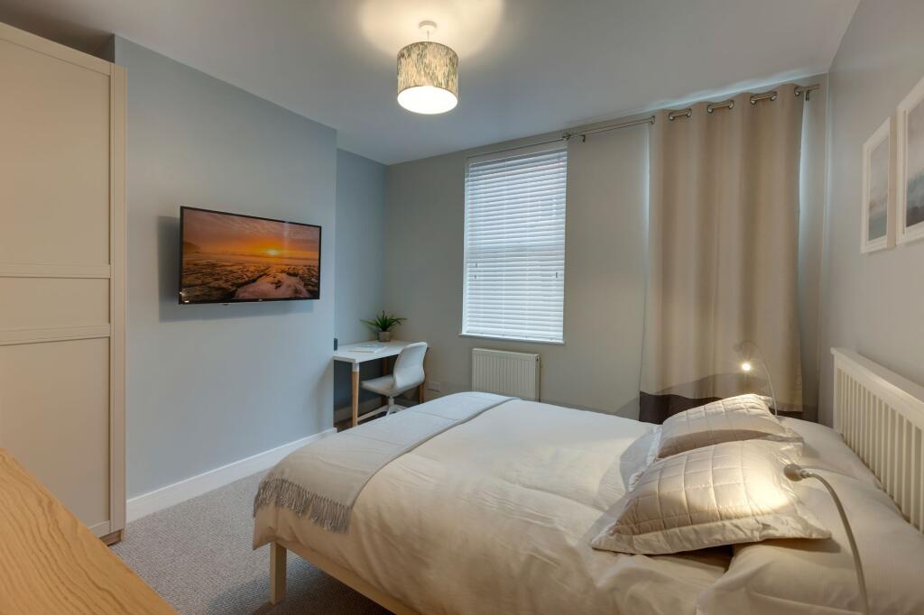 A cozy and well-maintained double bedroom featu...