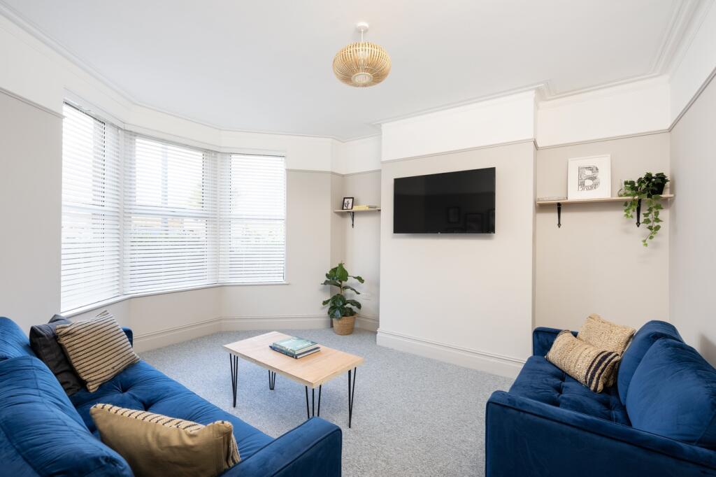 A spacious and well-lit modern living room with...