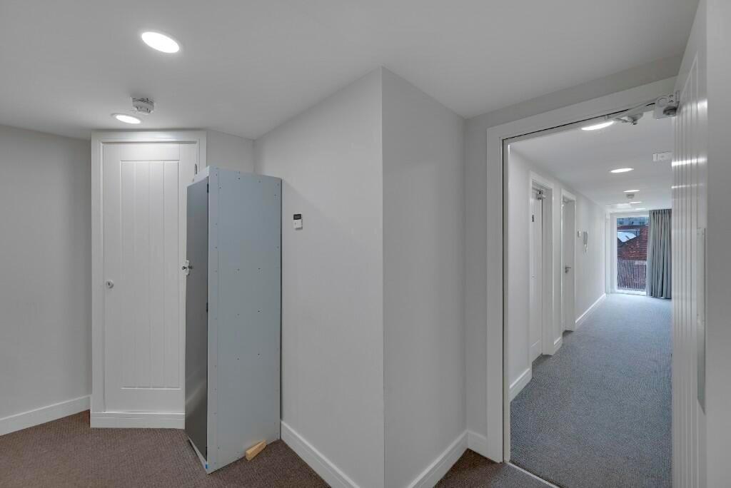 Bright and tidy hallway with clean white walls ...