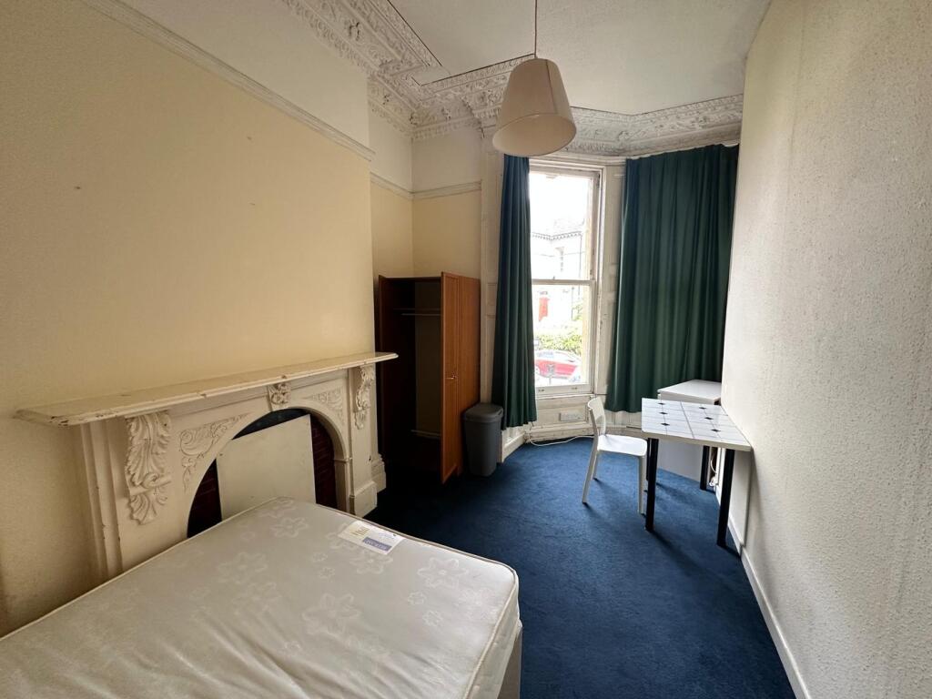 A spacious and inviting double bedroom with nat...