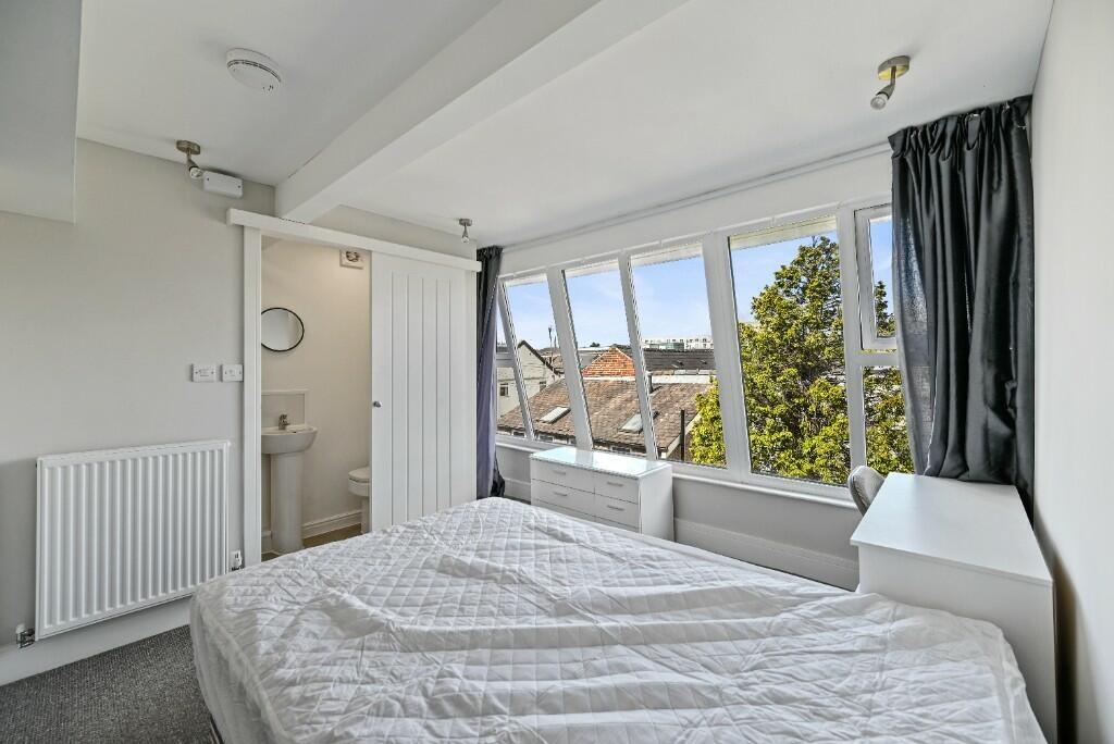 Bright and airy master bedroom featuring a larg...