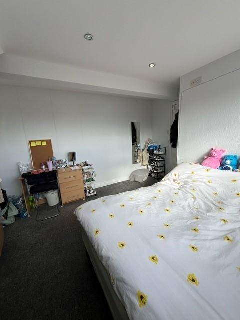 Bright, simply furnished bedroom with a double ...