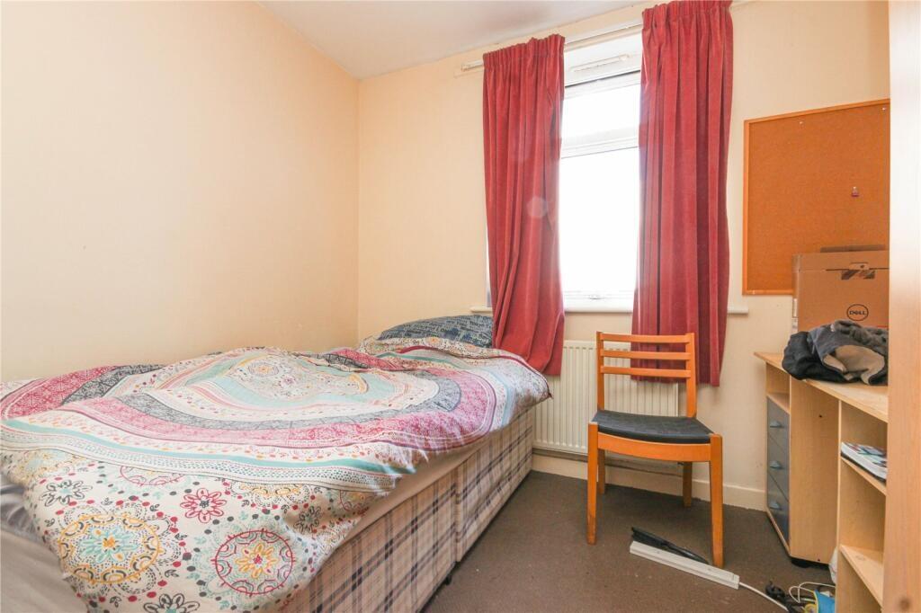 Cozy single bedroom featuring a comfortable bed...