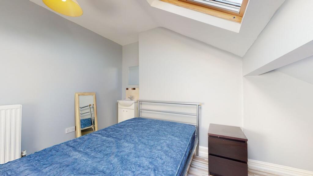 A compact bedroom featuring a metal-framed sing...