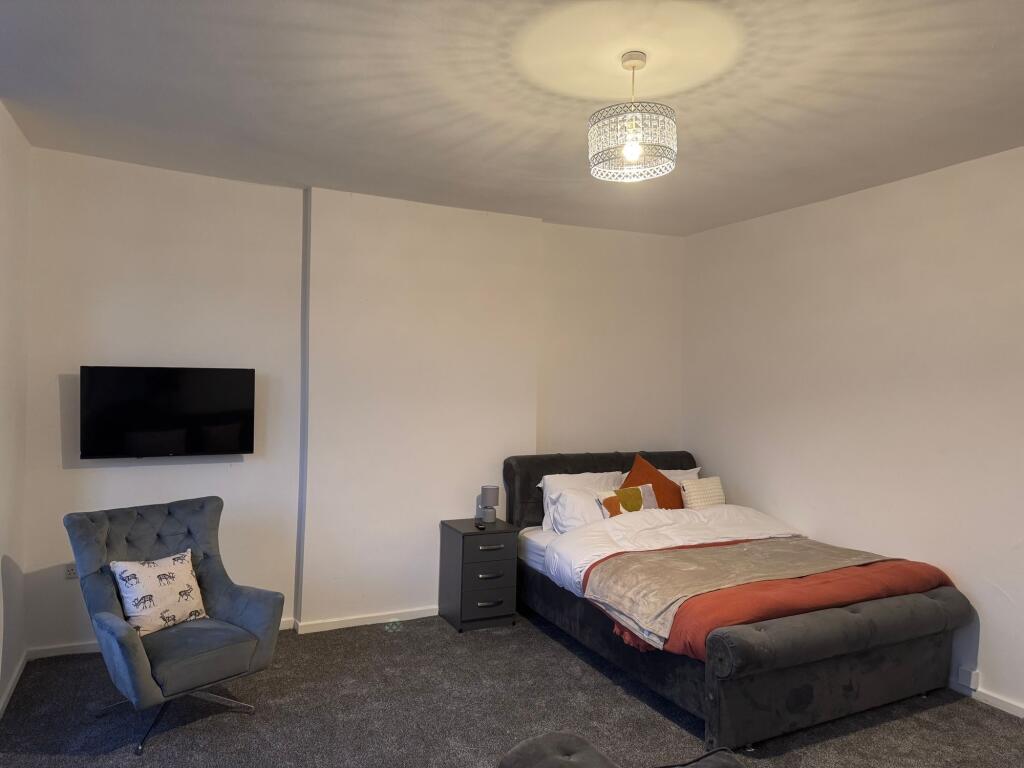 A cozy double bedroom featuring a plush dark up...