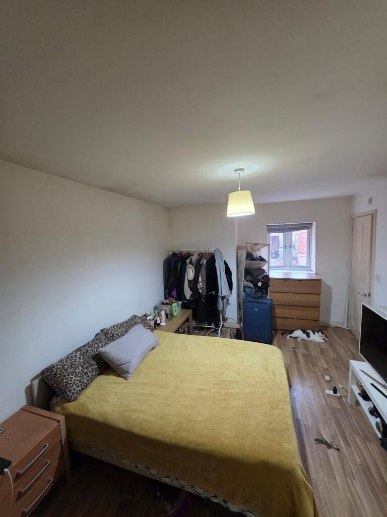 Bright, simply furnished bedroom with a double ...