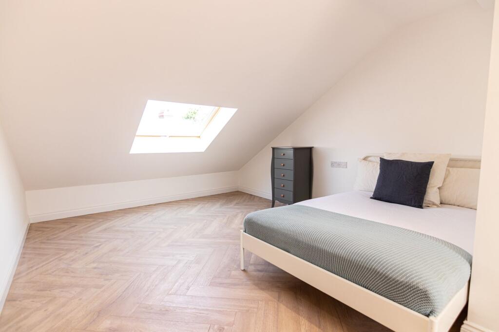 A bright, airy double bedroom featuring a comfo...