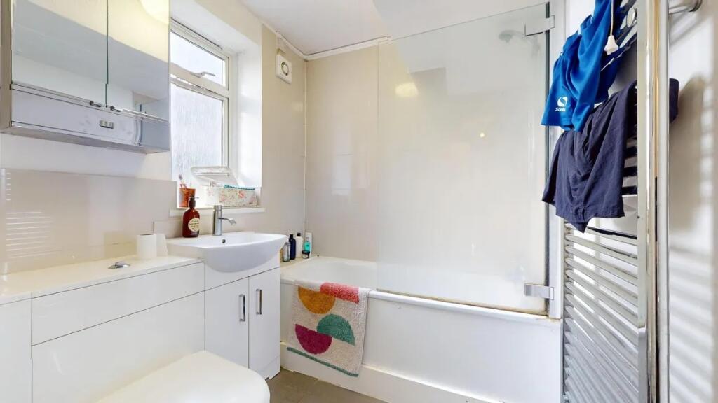 A bright and clean bathroom suite featuring a w...