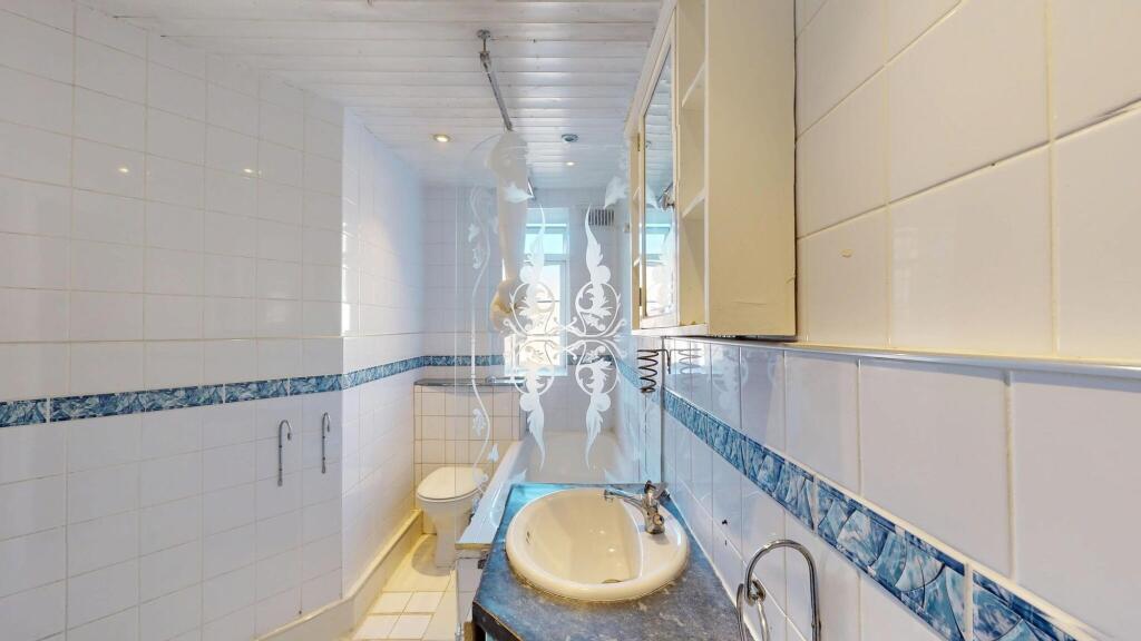 Bright and clean bathroom with a large bathtub,...