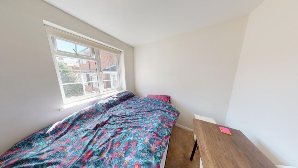 A bright and clean single bedroom featuring a l...