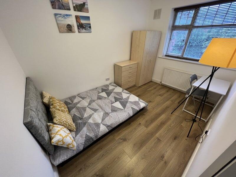 A clean and tidy single bedroom featuring wood-...