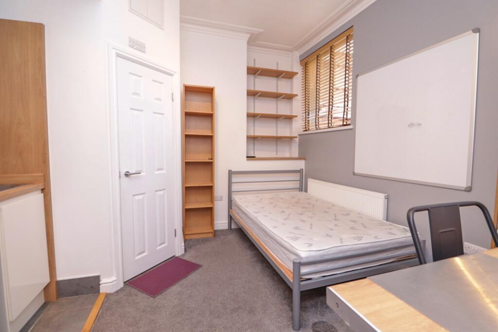 A tidy and well-lit double bedroom featuring sh...