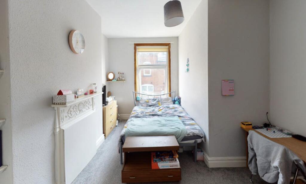 A cozy single bedroom with a neat bed, natural ...