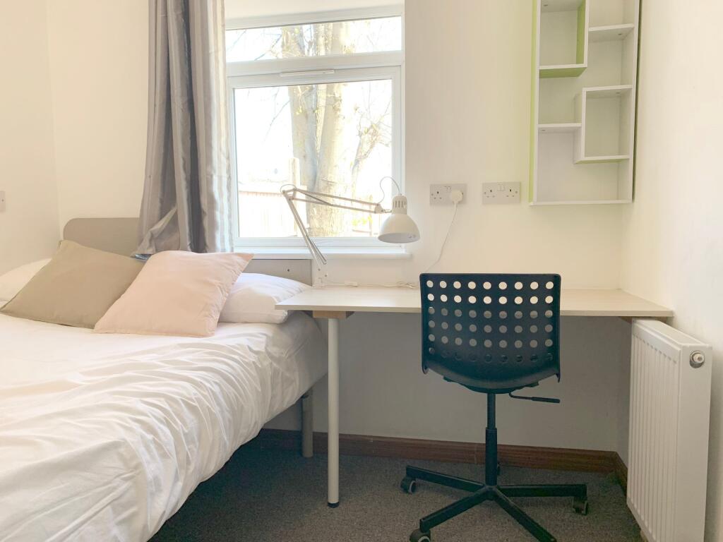 A bright and tidy single bedroom featuring a co...