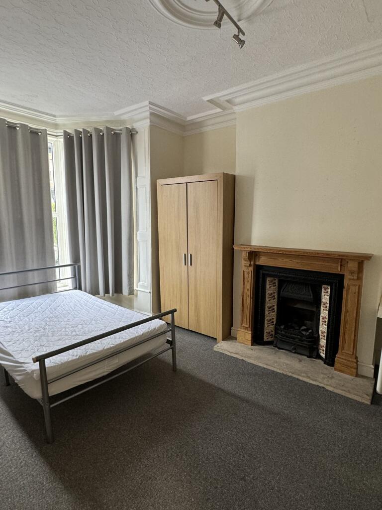 A spacious master bedroom featuring a comfortab...