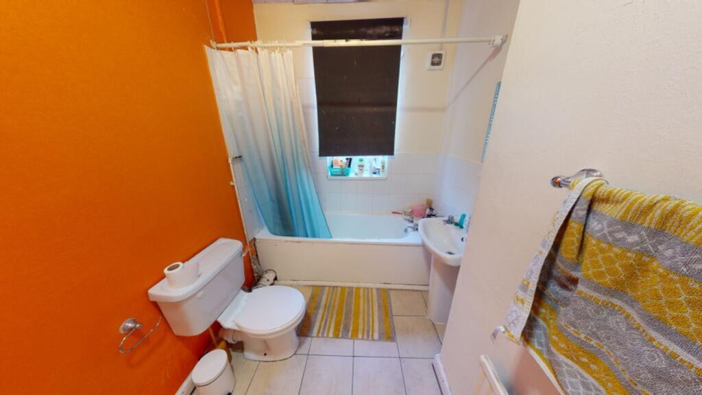 A bright and clean bathroom featuring a bathtub...