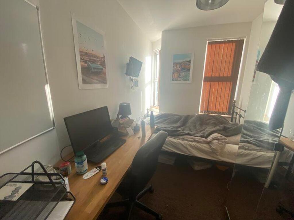 A cozy double bedroom with good lighting, a ded...