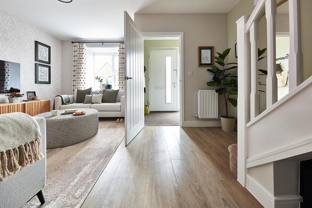 The inviting and spacious lounge offers space for fitted storage under the stairs
