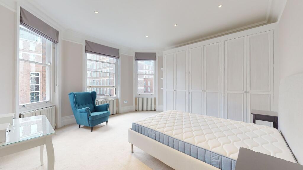 A bright and spacious master bedroom featuring ...