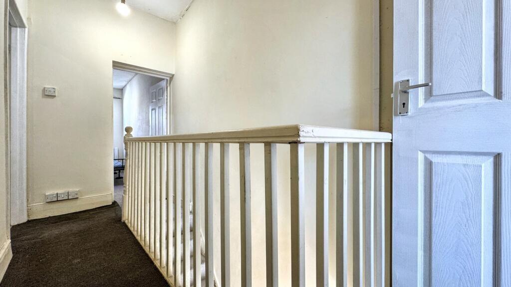 A bright and clean hallway featuring white wall...