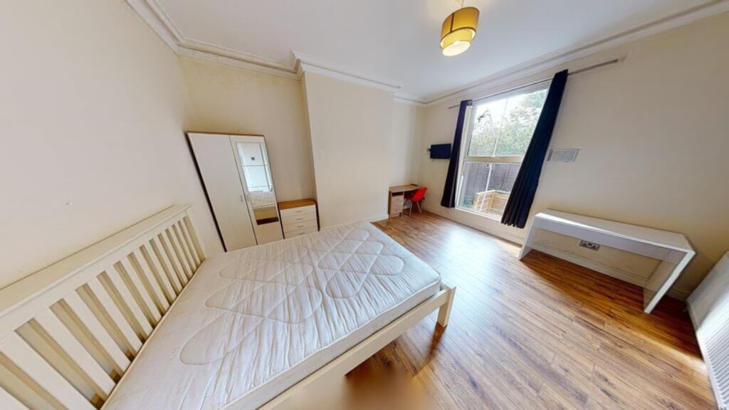 A spacious and bright double bedroom featuring ...