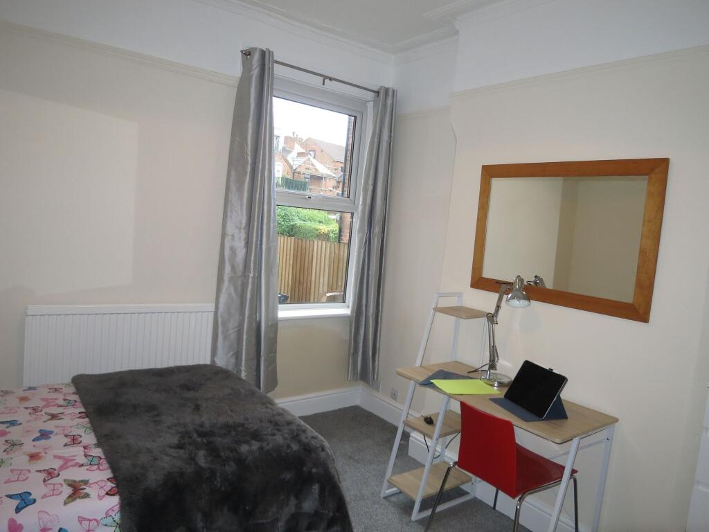 Bright and cozy single bedroom featuring a wind...