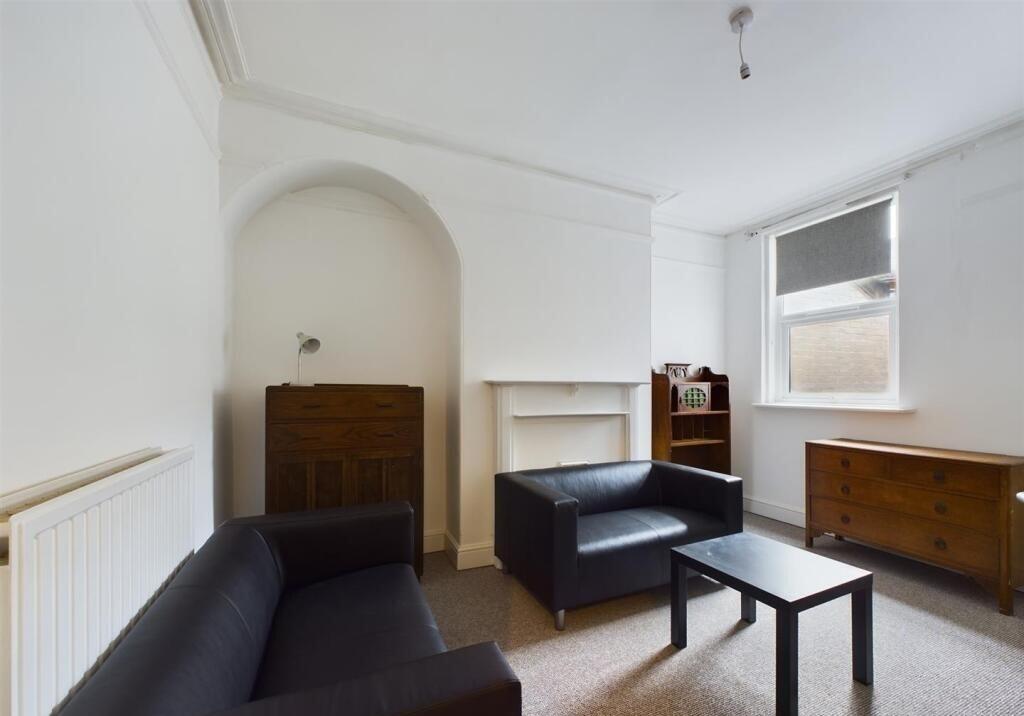 A cozy living room featuring two black leather ...
