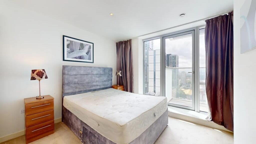 Bright and modern master bedroom featuring a la...