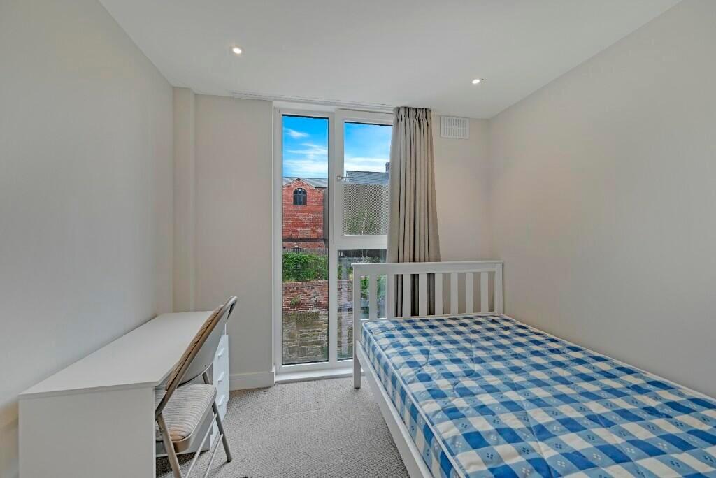 A bright and tidy single bedroom featuring a co...
