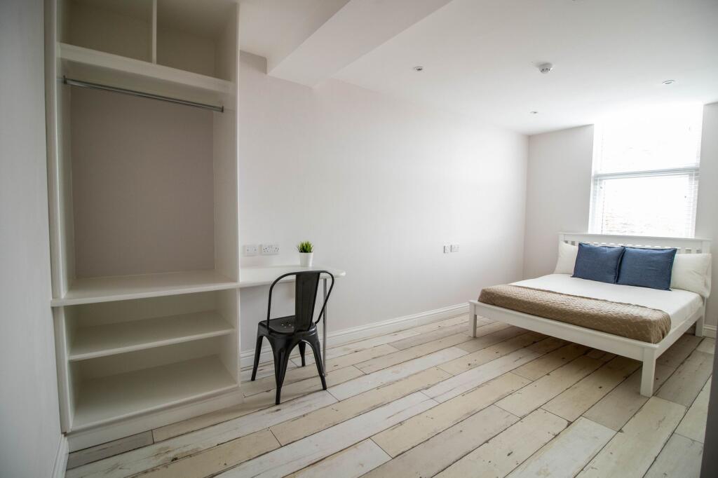 A bright and airy bedroom featuring a white bed...