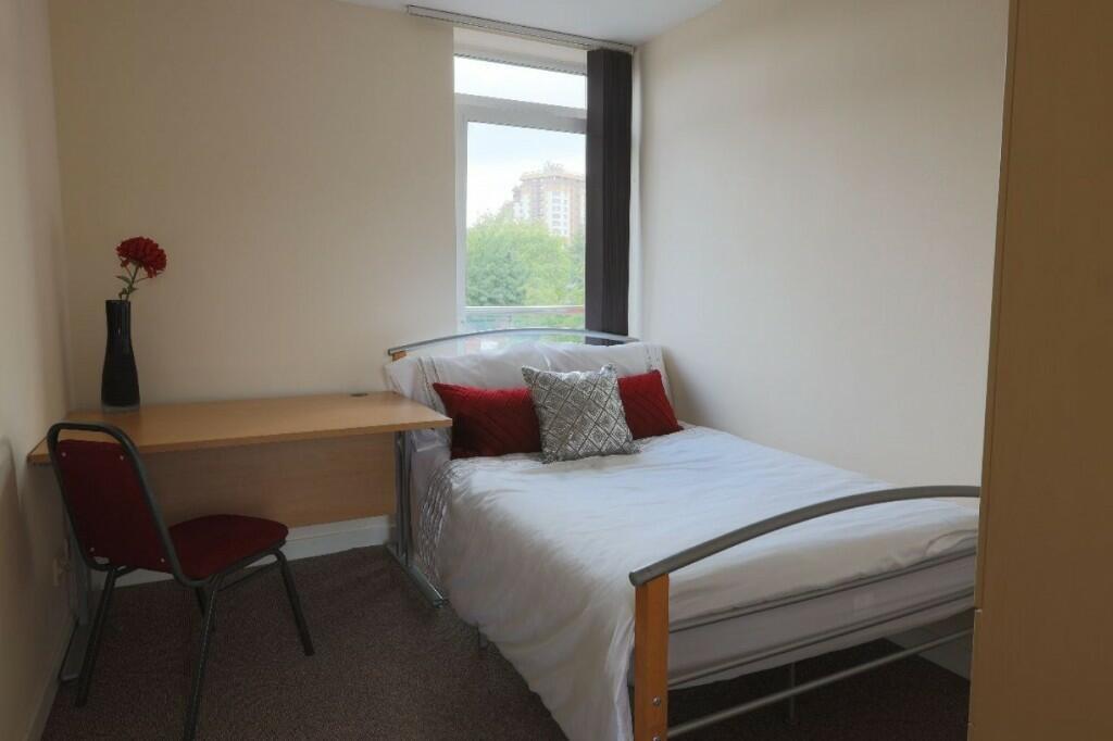 A cozy, well-lit single bedroom featuring a met...