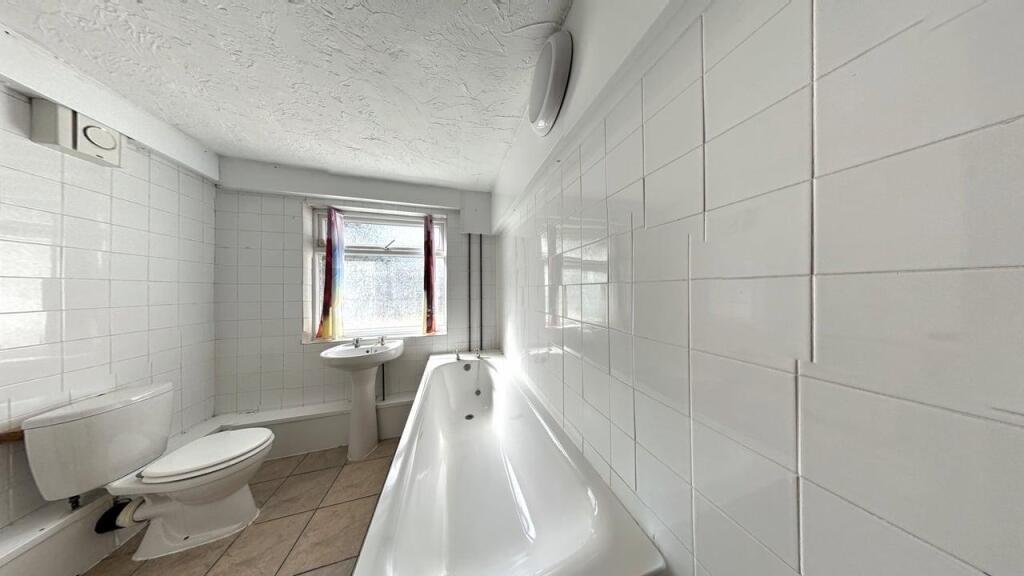 Bright and clean bathroom featuring a bathtub, ...