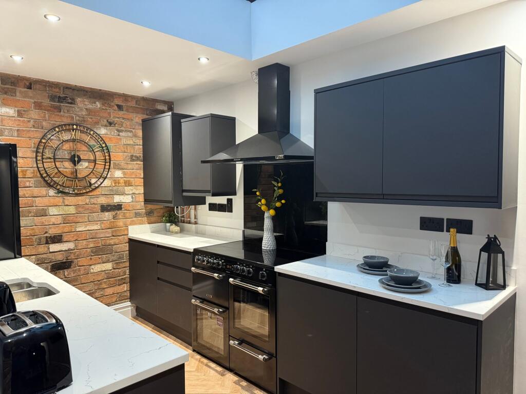 A modern and stylish kitchen featuring sleek bl...