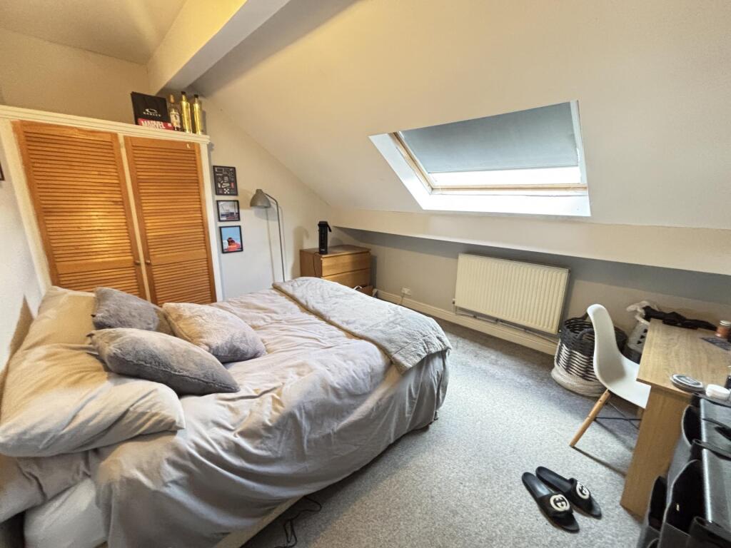 A cozy bedroom featuring a double bed with neat...