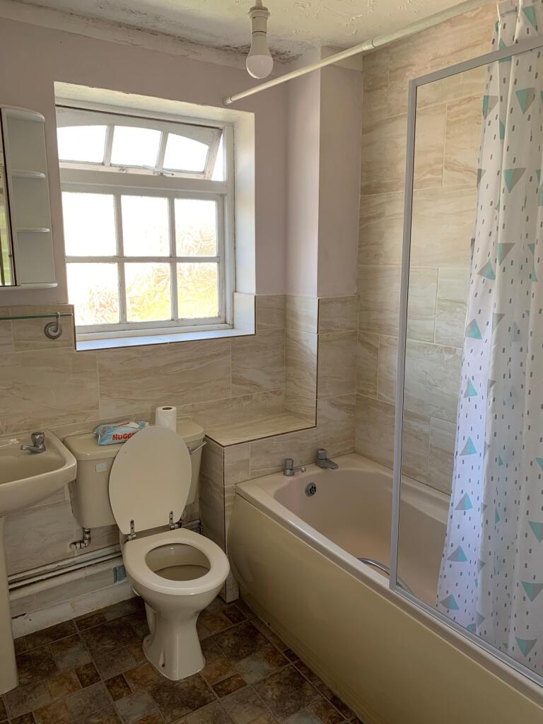A bright and tidy bathroom featuring a bath and...
