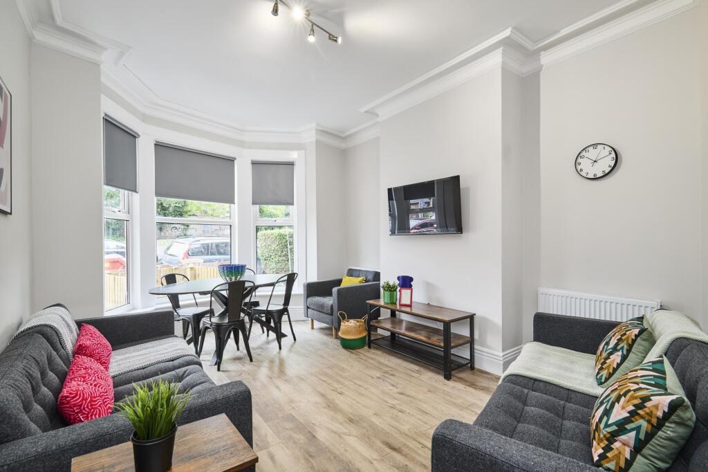 Bright and spacious living room featuring large...