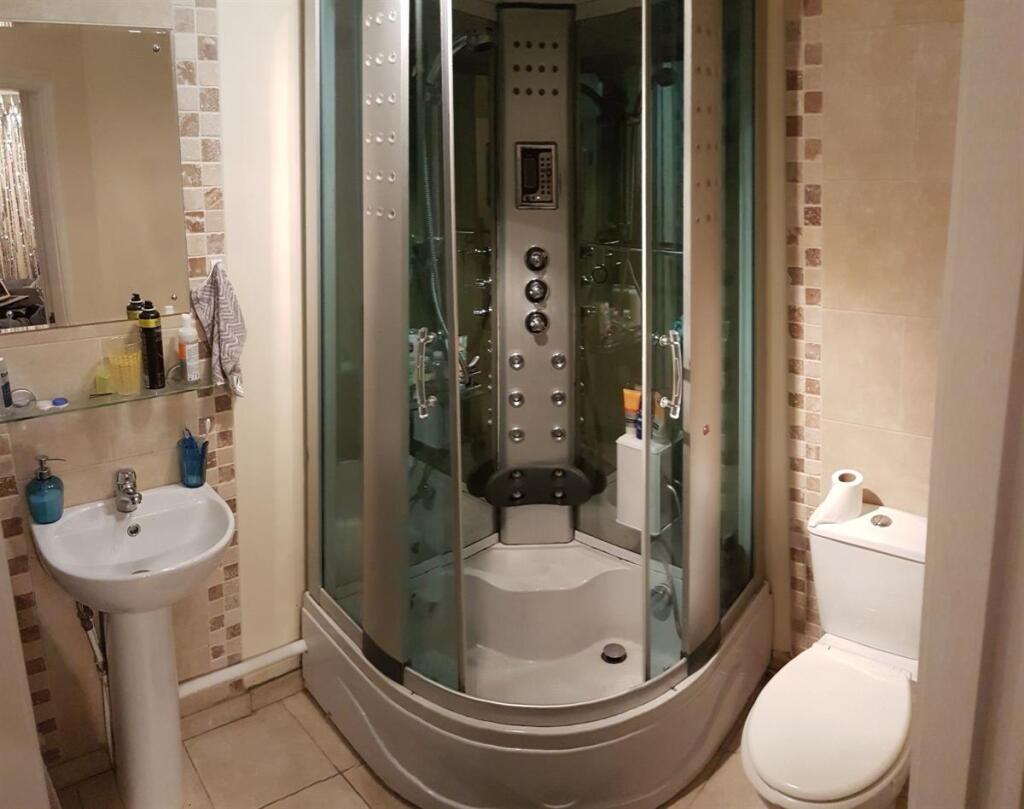 A modern bathroom featuring a large shower encl...
