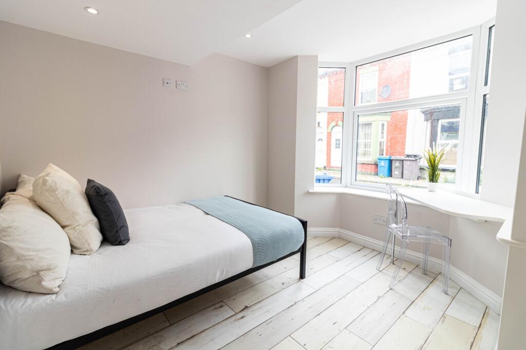 Bright and airy bedroom with large windows fill...