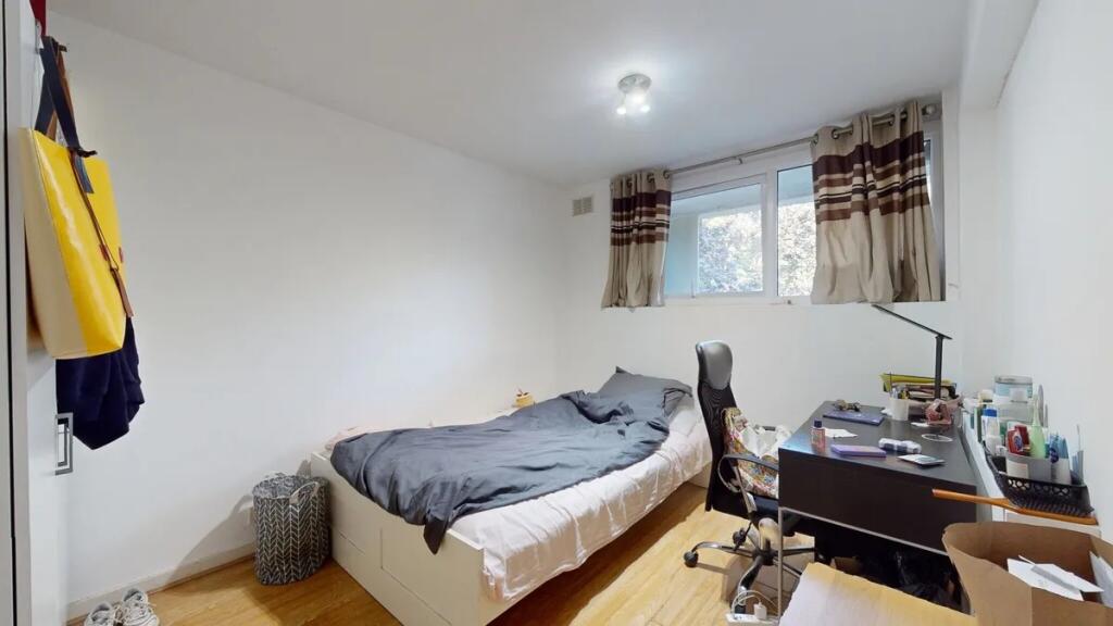 A tidy single bedroom featuring a comfortable b...