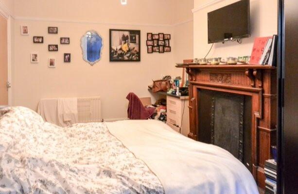 A cozy bedroom featuring a large bed with a hea...