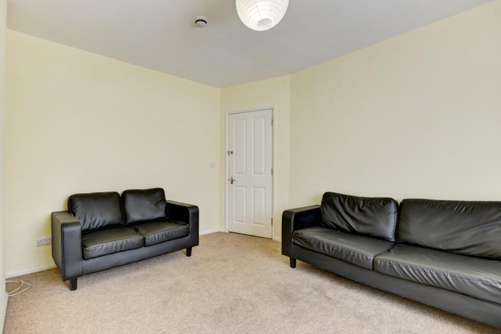 A simple and neat living room featuring two bla...