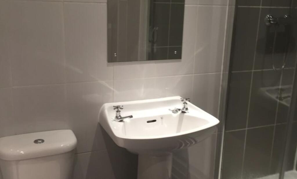 Modern tiled bathroom with a pedestal sink, WC ...