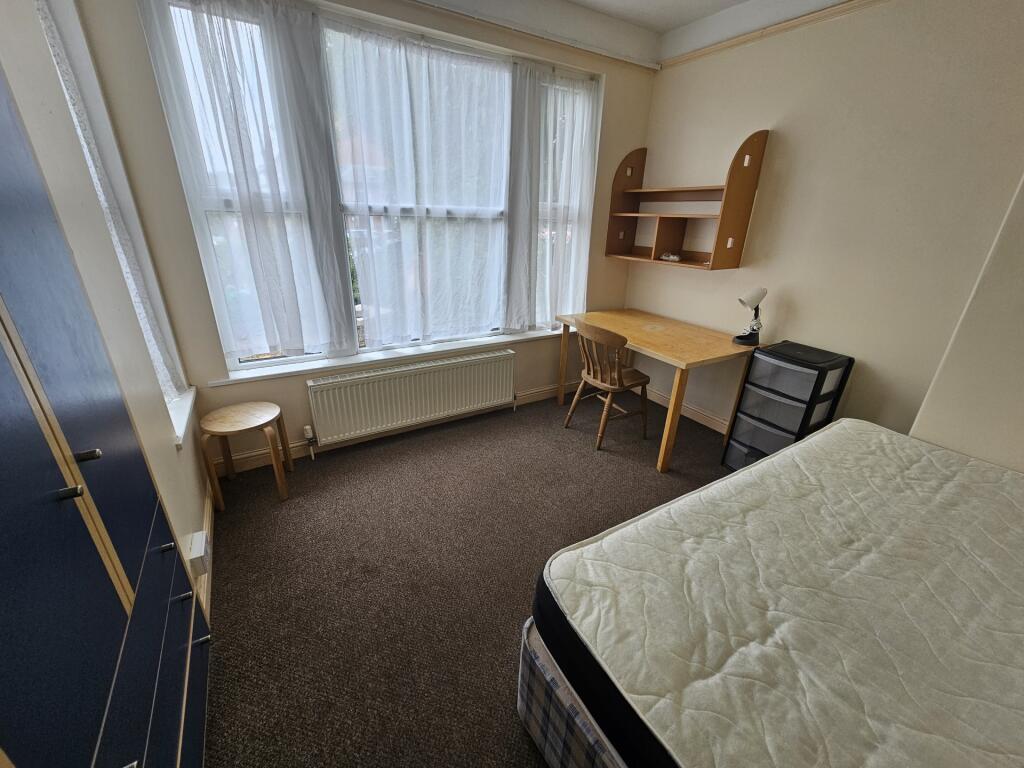 A bright and tidy single bedroom featuring a la...