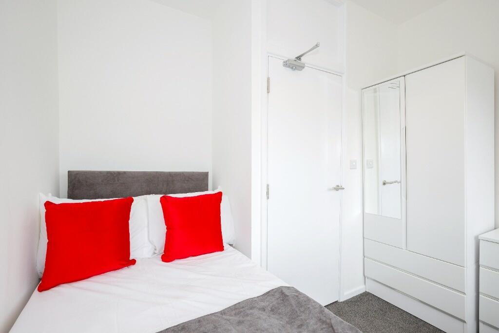 This cozy double bedroom features bright natura...