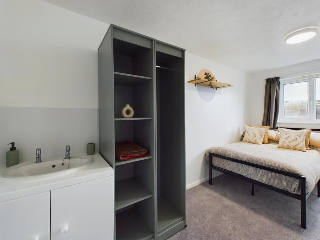A bright and tidy double bedroom featuring mode...