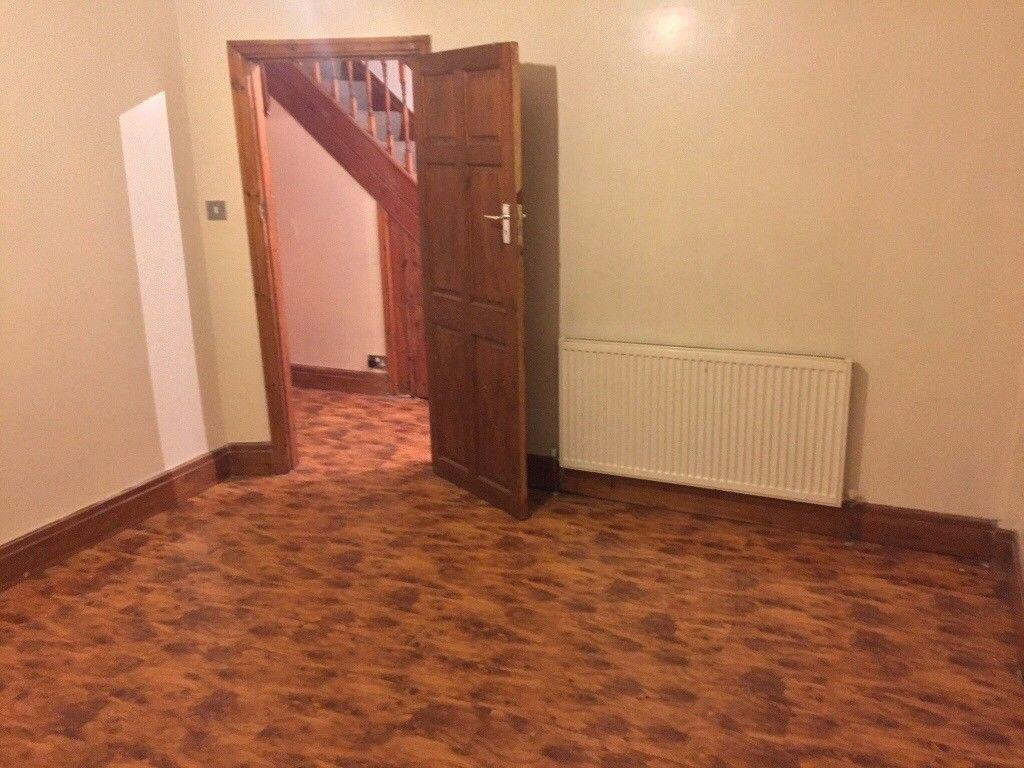 Empty living room with patterned laminate floor...