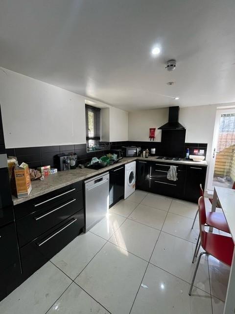 Modern galley-style kitchen with sleek black ca...